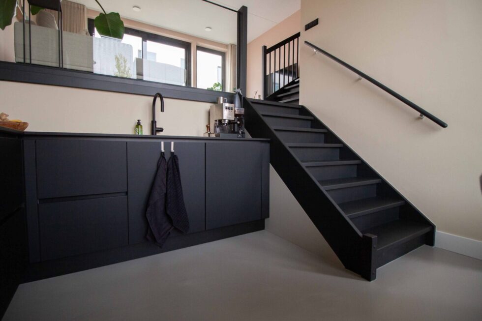 EPI Gietvloer met zwarte keuken en trap